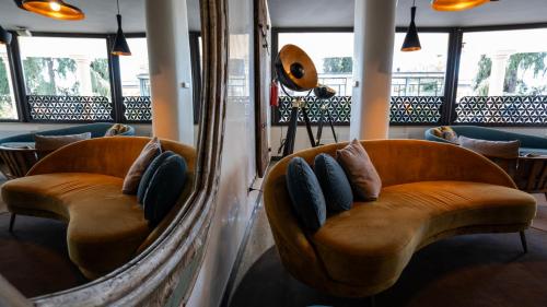 two chairs with pillows in a room with windows at Gardone Palace Hotel in Gardone Riviera