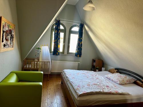 a bedroom with a bed and a green chair at Villa Illuminati in Gotha