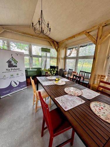 a dining room with a wooden table and chairs at Apartamenty i Winnica - Siedlisko Na Polanie in Lipka Wielka