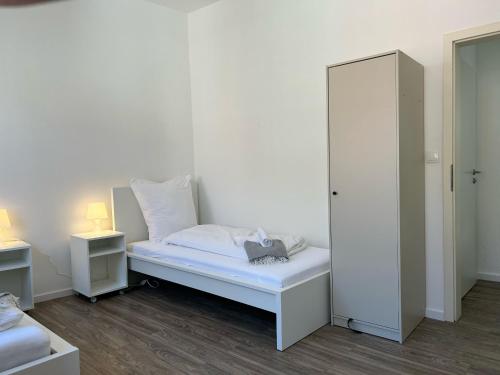 a white bedroom with a bed and a mirror at Convenient Apartment for 3 in Offenbach