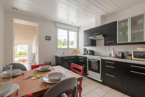 a kitchen with a wooden table and a dining room at Maison aux Moutiers - Wifi - Terrasse in Prigny