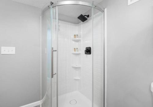 a shower with a glass door in a bathroom at Expertly Designed Lake Erie Escape with Hot Tub in Lorain
