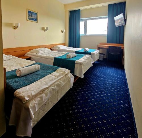 a hotel room with three beds and a desk at ----------------------------- Via Baltica Panevezys in Panevėžys