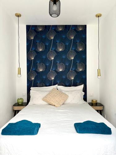 a bedroom with a white bed with a blue wall at Maison moderne en plein centre ville du Havre avec jacuzzi et parking gratuit in Le Havre