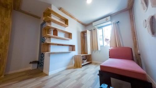 a room with a red chair and a window at Seawave Guest House in Hua Hin