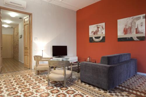 a living room with a couch and a tv at Rent Top Apartments Rambla Catalunya in Barcelona