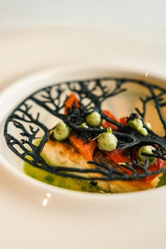 a bowl of food on a white plate at Tirolensis - Luxury All Inclusive in Tesimo