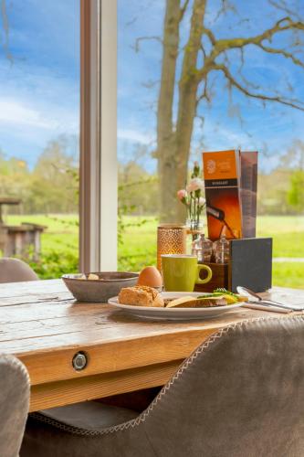 a table with a plate of food and a cup of coffee at Landhotel Diever in Diever
