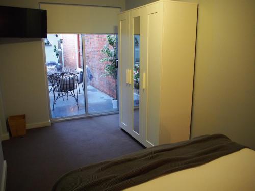 a bedroom with a door open to a patio at City Quarters on Brewer in Perth