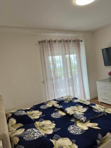 a bedroom with a blue bed with flowers on it at Luxury Sea View Apartment in Vlorë