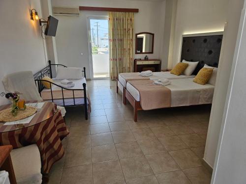 a hotel room with two beds and a living room at Apollonio Suites & Rooms Faliraki Rhodes in Faliraki