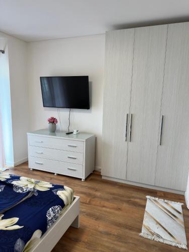 a bedroom with a tv and a white dresser at Luxury Sea View Apartment in Vlorë