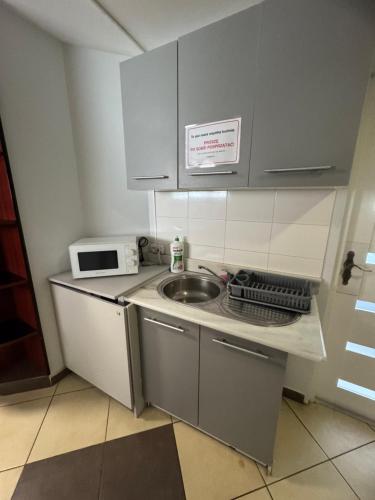 a small kitchen with a sink and a microwave at Hotels-Widok Rynek - Centrum &Parking -fak VAT in Kielce