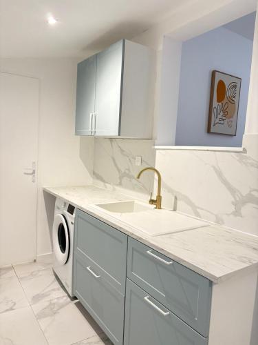 a kitchen with a sink and a washing machine at Maison moderne en plein centre ville du Havre avec jacuzzi et parking gratuit in Le Havre