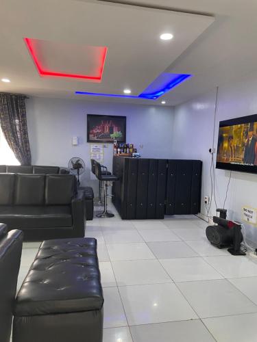 a living room with a couch and a tv at Umbrella Properties hotels and apartments - Moniya in Ibadan