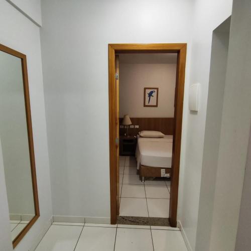 a room with a bedroom with a bed and a mirror at Golden Dolphin Grand Hotel piscinas 24 hs MP in Caldas Novas