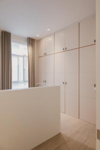 a kitchen with white cabinets and a white counter at Blue Bird Residence in Antwerp