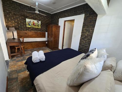 a bedroom with a bed with two towels on it at Pine Valley in Lanseria