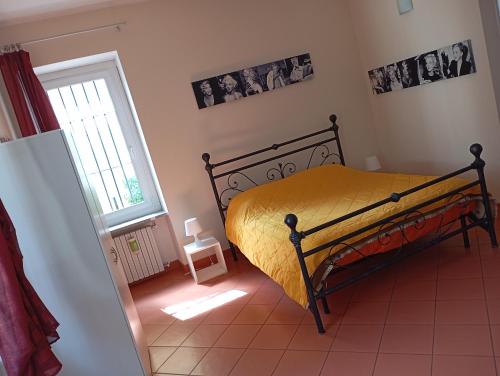 a bedroom with a bed with a yellow bedspread at "B&B Sans égal", con CAMERE PRIVATE e APPARTAMENTI al PIANO TERRA a Biella in Biella
