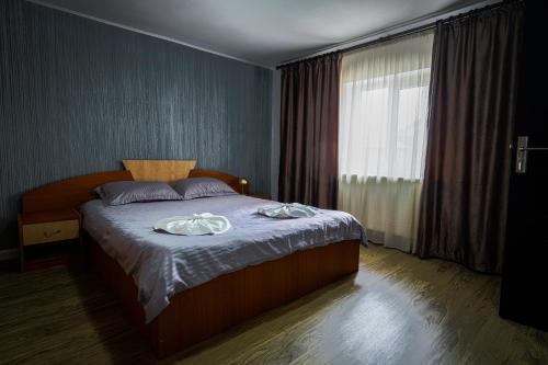a bedroom with a bed with two towels on it at Casa Andra in Baia de Fier
