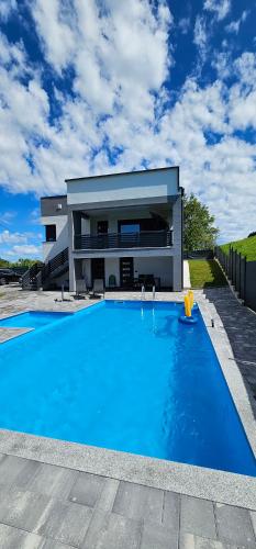 a large swimming pool in front of a house at Villa Vienna in Bužim