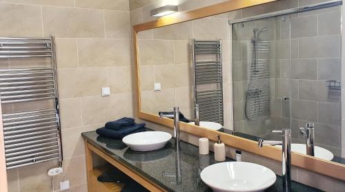 Un baño con dos lavabos y un espejo grande. en Fantástica V3 Vista Mar & Golfe Praia Del Rey, Óbidos, en Amoreira