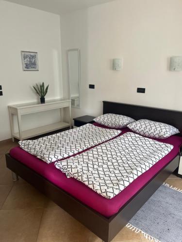 a bedroom with a large bed with a purple mattress at Villa Markisa in Rukavac