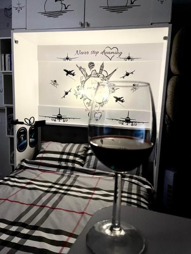 - un verre de vin assis sur une table à côté d'un lit dans l'établissement Petit Bijou niçois, à Nice