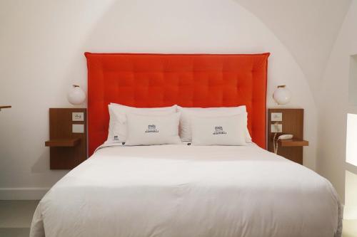 a bed with an orange headboard and two white pillows at Palazzo Martinelli in Sorrento
