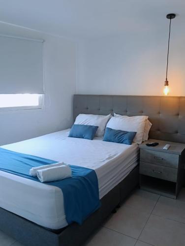 a bedroom with a large bed with blue pillows at Apartamento en centro histórico in Cartagena de Indias