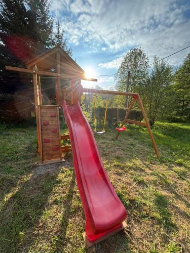 a playground with a red slide and a swing at Roubenka Vanedi in Olešnice v Orlických horách