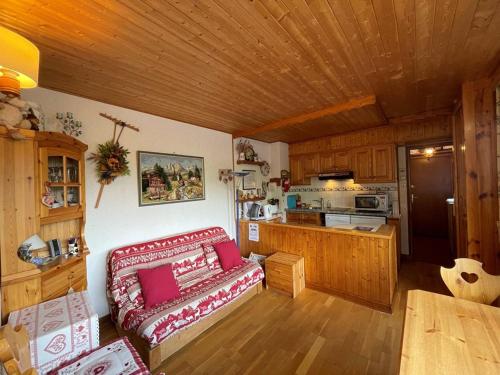 un salon avec un canapé rouge et une cuisine dans l'établissement Appartement cosy 4 pers, au coeur de Crest-Voland, proche pistes, parking, balcon - FR-1-733-80, à Crest-Voland