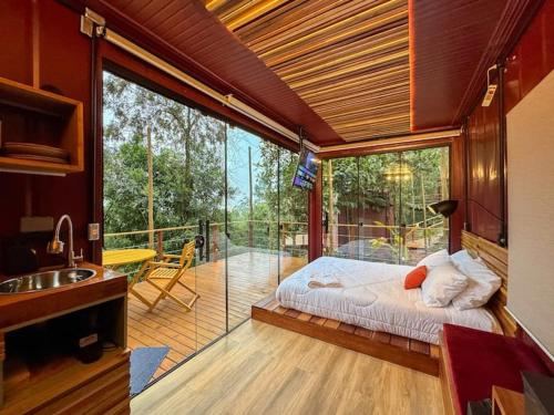 a bedroom with a bed on a balcony at Tucano - Deck Tiny House in Mairiporã