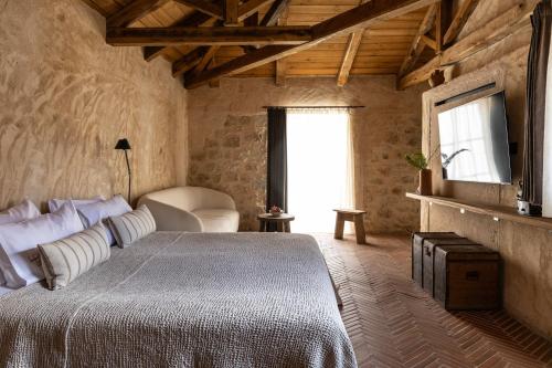 a bedroom with a bed and a tv on a wall at Amalen Suites Adults Only in Rethymno Town