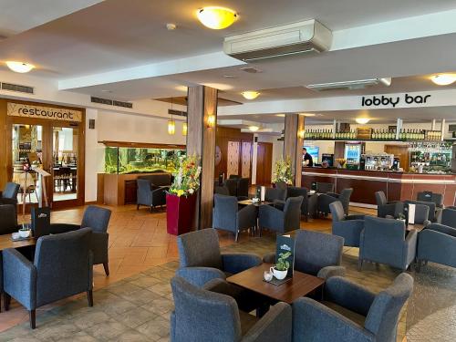 a restaurant with chairs and tables and a bar at Tatralandia apartment in Liptovský Mikuláš