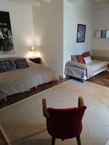 - une chambre avec 2 lits et une chaise dans l'établissement La Huppe - Chambre d'hote, à Yversay