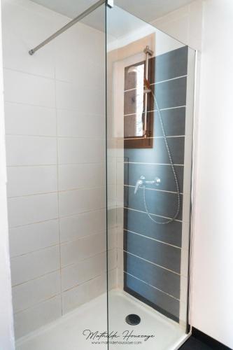 une douche avec une porte vitrée dans une salle de bain dans l'établissement Gite T3 Le Balarino - Mercantour 1, à Belvédère