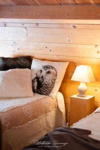 un hibou sur un oreiller sur un lit avec une lampe dans l'établissement Gite T3 Le Balarino - Mercantour 1, à Belvédère