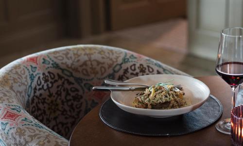 a bowl of food on a table with a glass of wine at Teach de Broc in Ballybunion