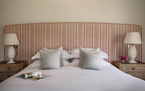 a bedroom with a large bed with white sheets and pillows at Teach de Broc in Ballybunion