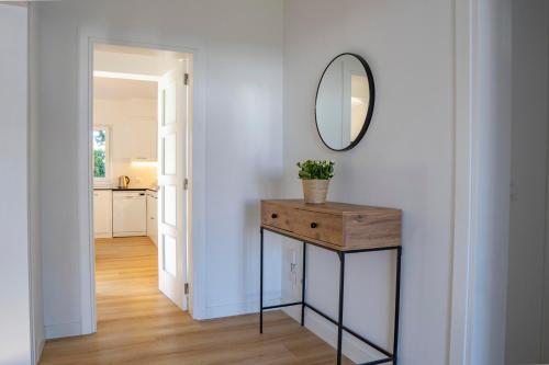 a hallway with a table and a mirror on a wall at VILLA SAVINA in Cala en Blanes