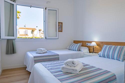 two beds in a room with towels on them at VILLA SAVINA in Cala en Blanes