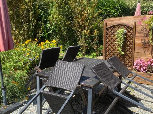 einen Tisch und Stühle in einem Garten mit Blumen in der Unterkunft Kergarec gite H in Clohars-Fouesnant