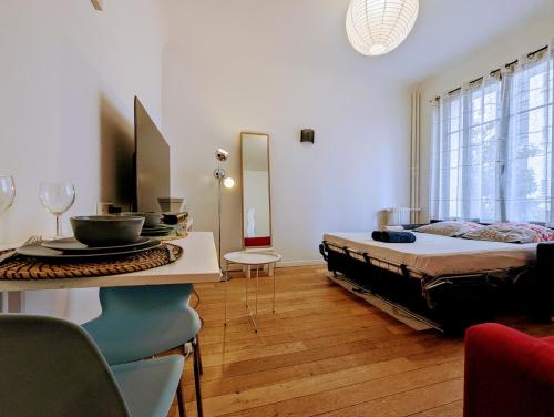 une chambre avec un lit et une table dans une pièce dans l'établissement Chic and comfortable studio near Paris, à Boulogne-Billancourt