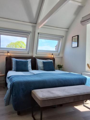 a bedroom with two beds and two windows at Appartement Havenzicht in Enkhuizen