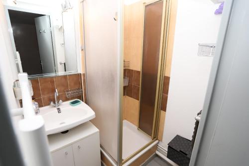 une salle de bain avec un lavabo et une douche dans l'établissement St Cyprien plage Maison avec terrasse et 2 velos, à Saint-Cyprien