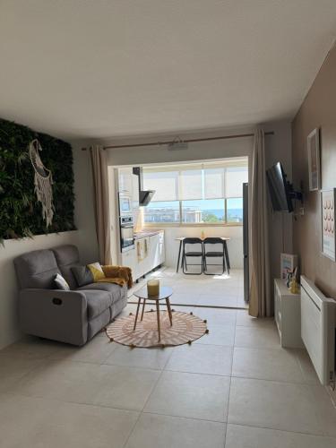 un salon avec un canapé et une table dans l'établissement Studio Cosy vue mer, à Antibes