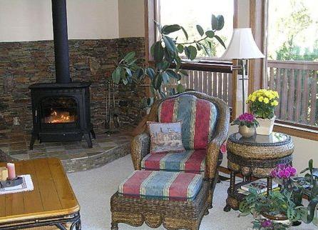 a living room with a chair and a fireplace at End of the road B & B in Cranbrook