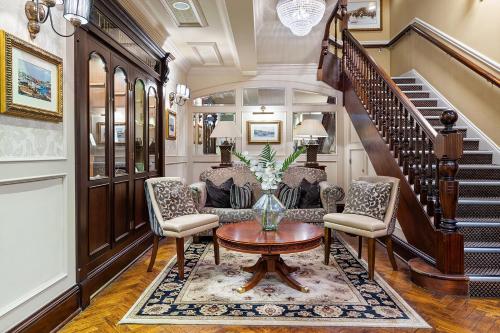 a living room with a table and chairs and a staircase at The Royal Hotel Campbeltown in Campbeltown