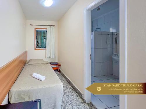 a small bedroom with a bed and a shower at Hotel Fazenda Golden Park Campos do Jordão in Campos do Jordão